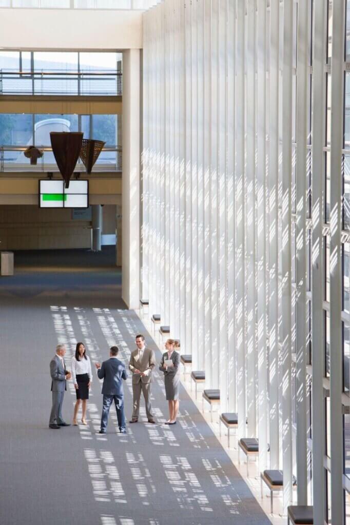 Private security officer in business attire providing a discreet presence in a modern office lobby during an HR-related meeting.