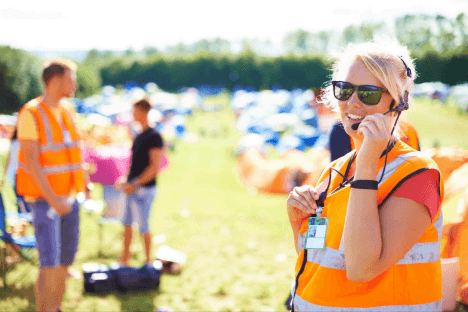 Volunteer staff at an outdoor event greet guests and provide directions