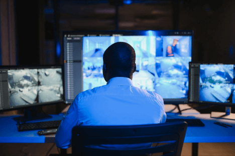 Security professional monitor surveillance feeds in a control room, supporting incident response and reporting.