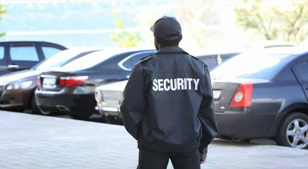 Security patrol vehicle monitoring a Denver business parking lot