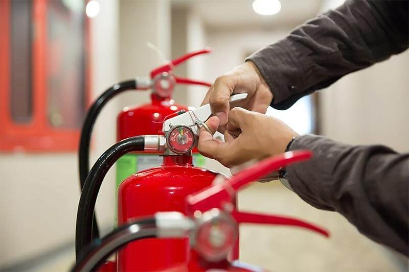 Fire watch guard checking fire extinguisher and exit route in Denver